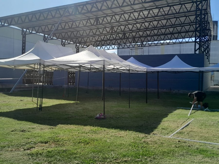 Gazebos armados en fila para un evento, estructura y lona vistas de frente