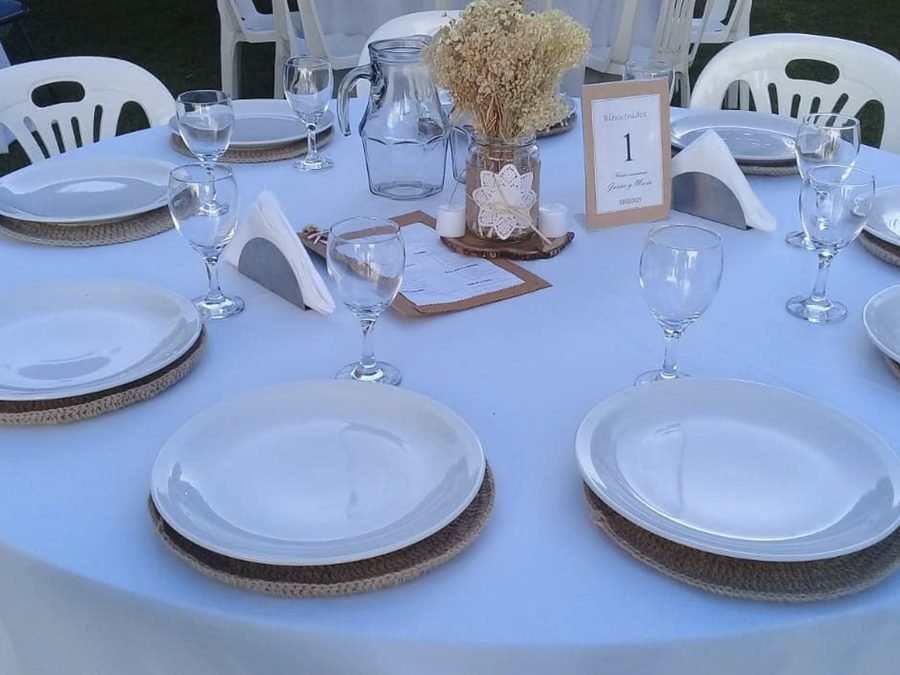 Mesa vestida con mantelería y vajilla para un evento