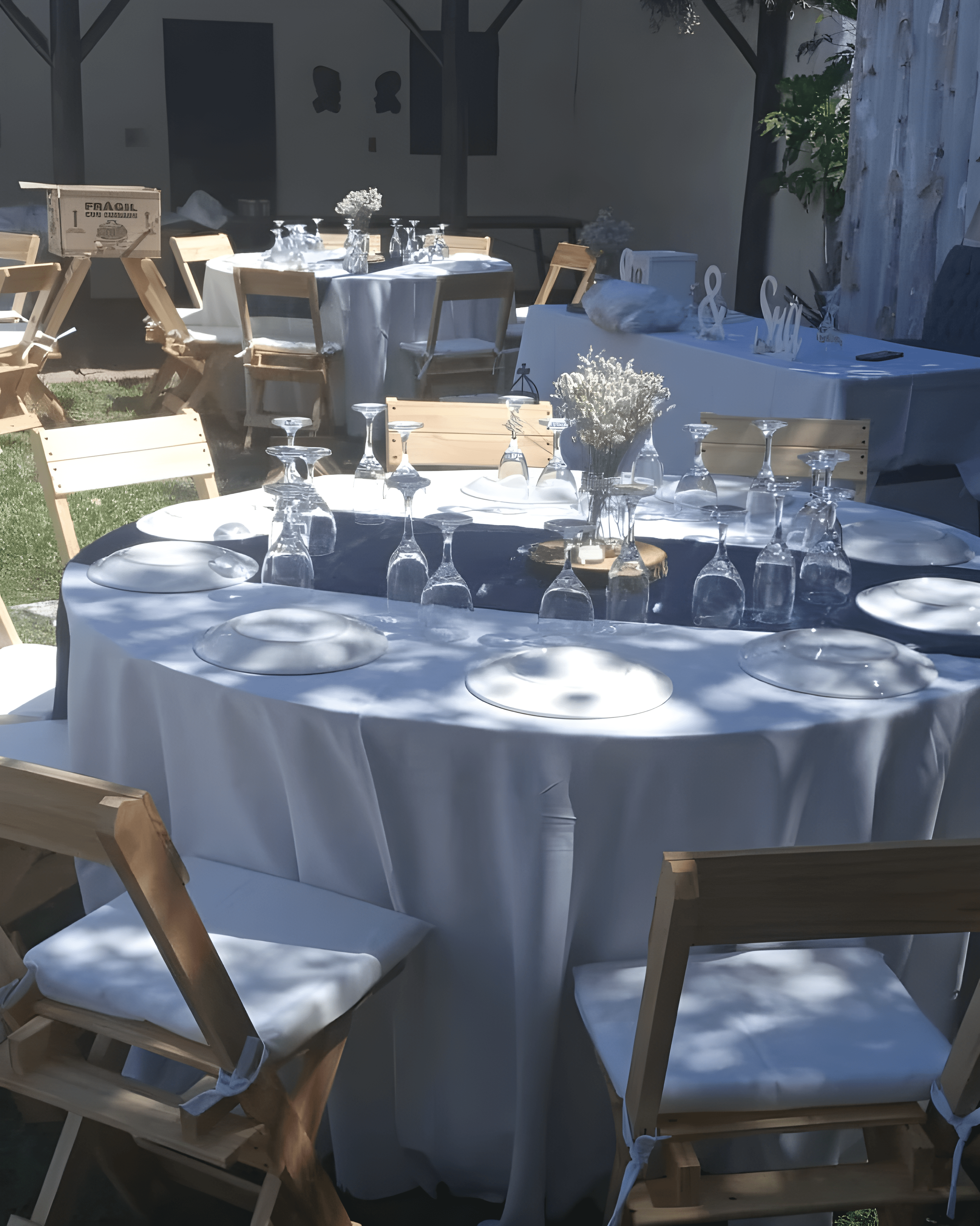 Mesa en un evento al aire libre con mantelería blanca y vajilla de porcelana